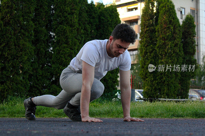 A white man stretching himself in a public park